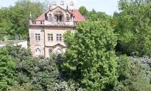 The Waldschlösschen framed by lilac flowers as it can be seen from our terrace.